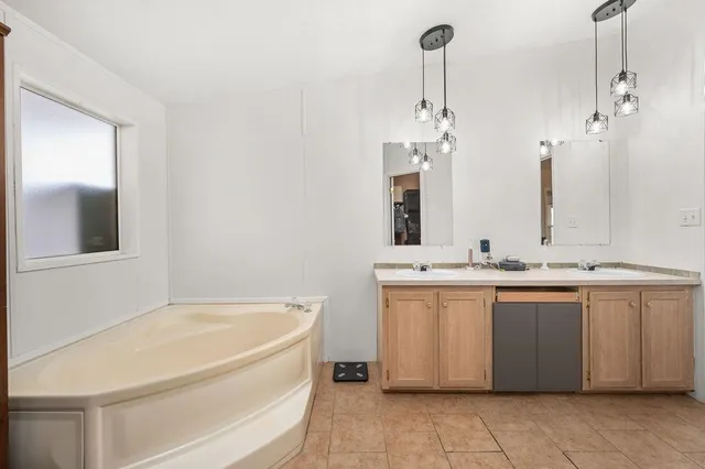 a bathroom with a granite countertop sink and a bathtub