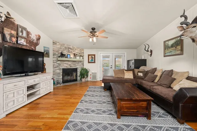a living room with furniture a flat screen tv and a fireplace