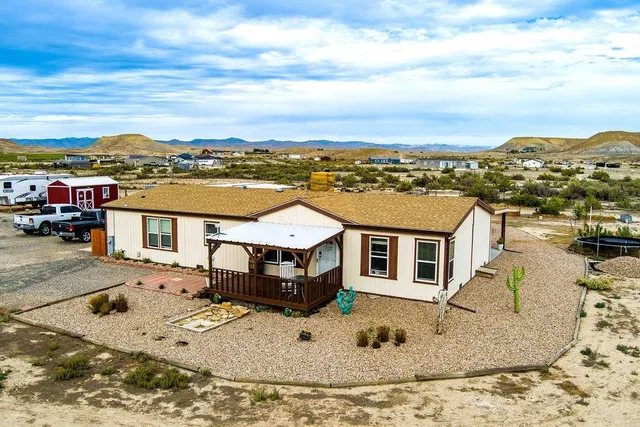 an aerial view of a house with a mountain