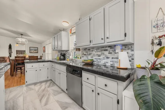 a kitchen with granite countertop a sink a stove and cabinets