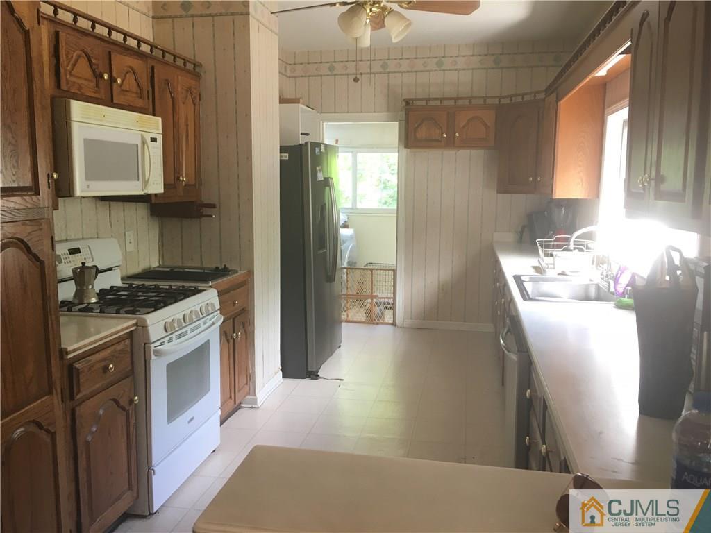 2 Matawan Road Old Bridge, NJ 08879 - Photo 13 of 15 a kitchen with stainless steel appliances granite countertop a refrigerator a stove and a sink with wooden floor