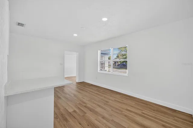 a view of an empty room with wooden floor