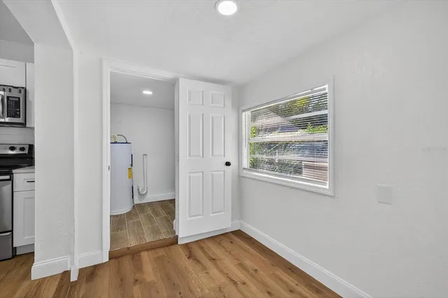 an empty room with wooden floor and a window