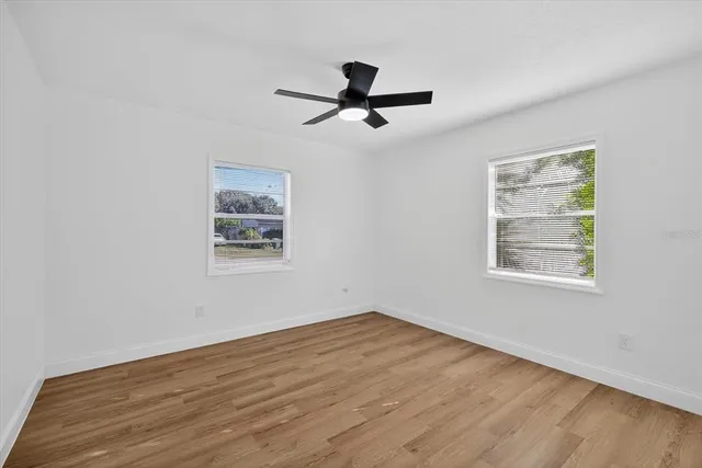 a view of empty room with wooden floor