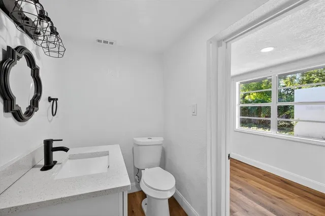 a bathroom with a toilet a sink and a window