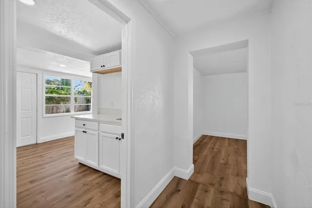 an entryway with wooden floor and cabinet
