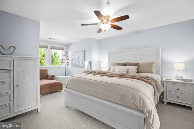 a bedroom with a bed a chandelier and a window