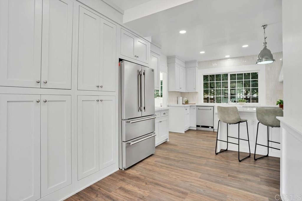 1864 Sunset Boulevard San Diego, CA 92103 - Photo 12 of 57 a kitchen with white cabinets and wooden floor