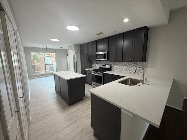 a kitchen with a refrigerator and a stove top oven