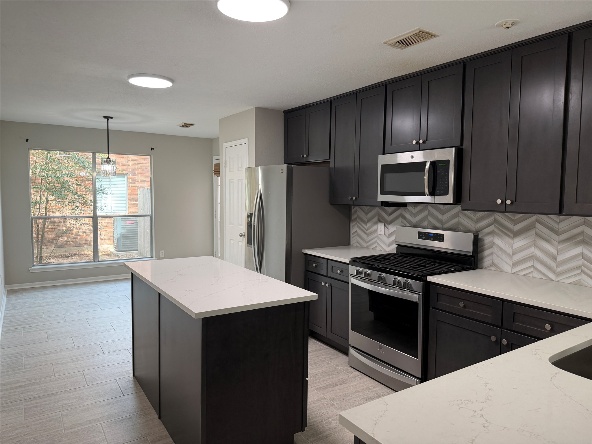 75 East Village Knoll Circle Spring, TX 77381 - Photo 13 of 33 a kitchen with stainless steel appliances kitchen island granite countertop a stove a refrigerator and a sink