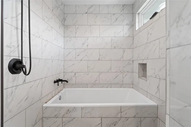 a bath tub sitting next to a white sink and a shower