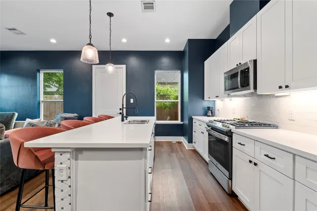 a kitchen with stainless steel appliances a stove a sink island and a refrigerator