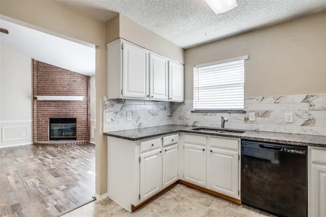 a kitchen with granite countertop cabinets sink and stove