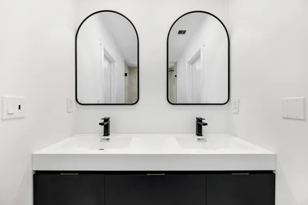 a bathroom with double vanity sinks and a mirror