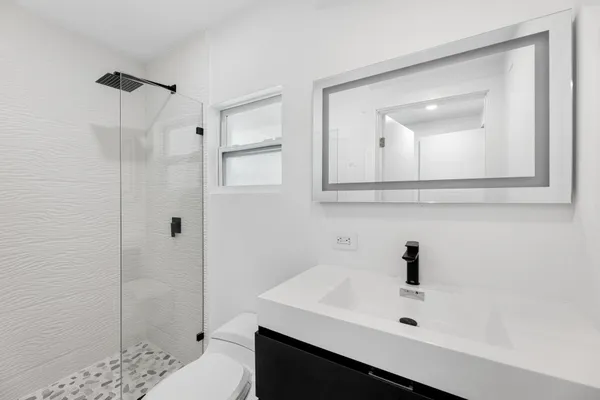 a bathroom with a sink a shower and mirror