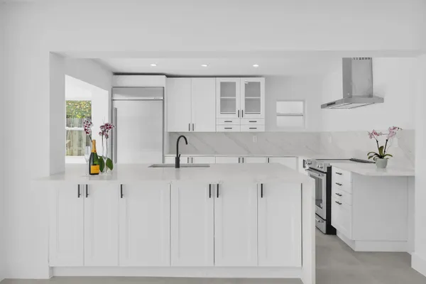 a kitchen with stainless steel appliances a sink a stove a refrigerator a window