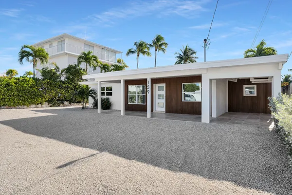 a view of a house with a yard and potted plants