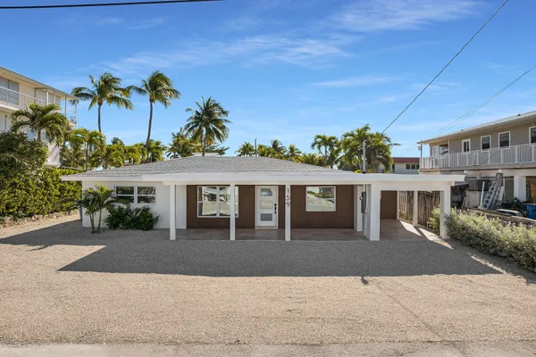 a front view of a house with a yard and potted plants