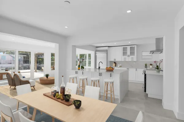 a living room with furniture a large window and kitchen view