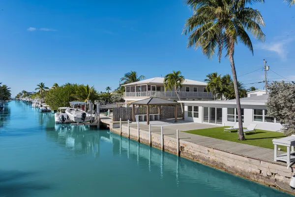 a view of a house with pool and chairs