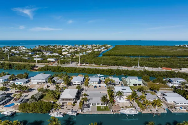 an aerial view of ocean and residential houses with outdoor space