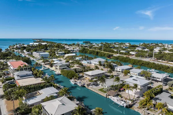 an aerial view of a city with lots of residential buildings and ocean view