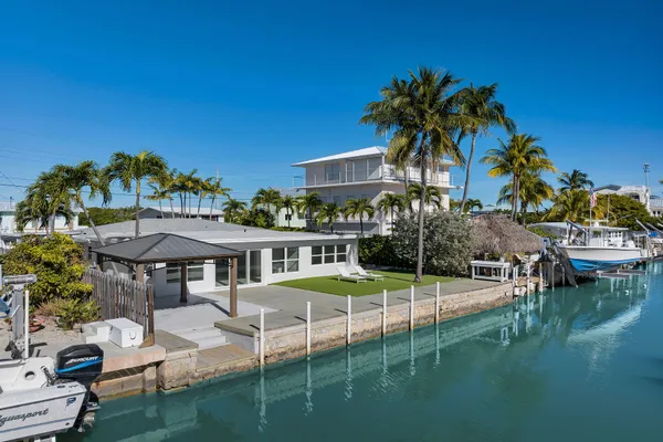 a view of a house with pool and chairs