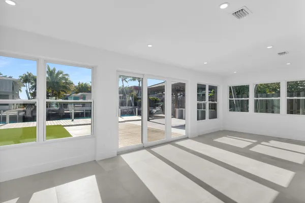 a large white kitchen with a large window and swimming pool