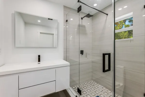 a bathroom with a shower sink and mirror