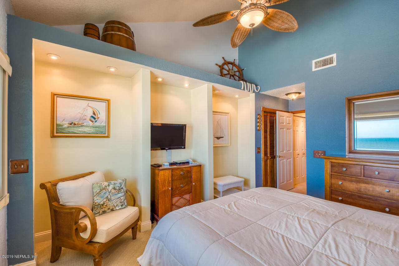 8550 A1A South, Unit 408 St. Augustine, FL 32080 - Photo 16 of 33 a bedroom with a bed couch and a flat screen tv