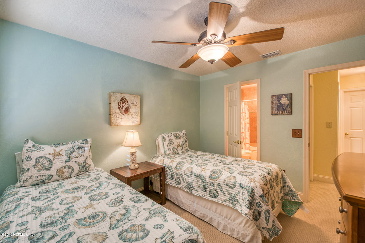 8550 A1A South, Unit 408 St. Augustine, FL 32080 - Photo 21 of 33 a bedroom with a bed and a chandelier