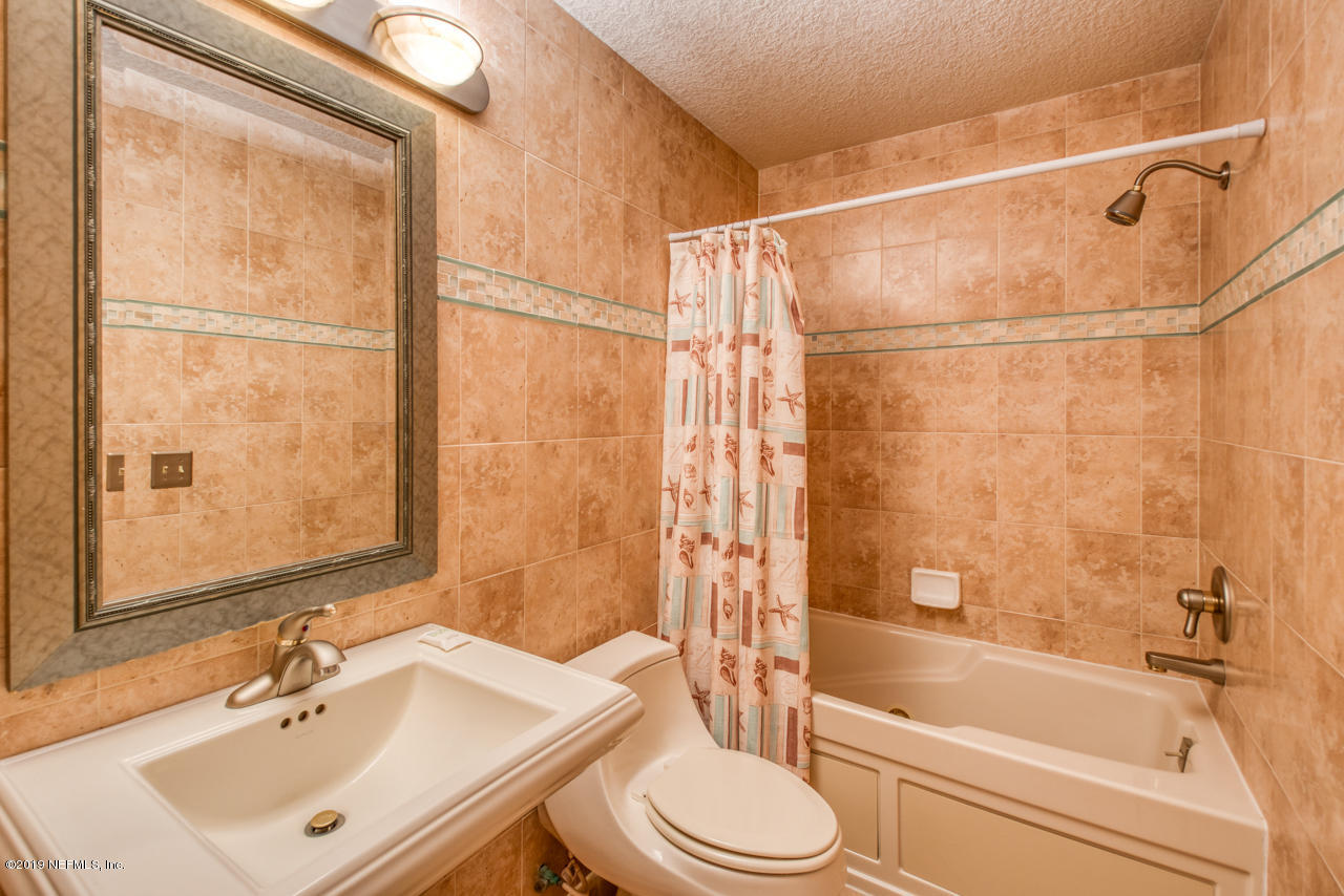 8550 A1A South, Unit 408 St. Augustine, FL 32080 - Photo 23 of 33 a bathroom with a sink mirror toilet and bathtub