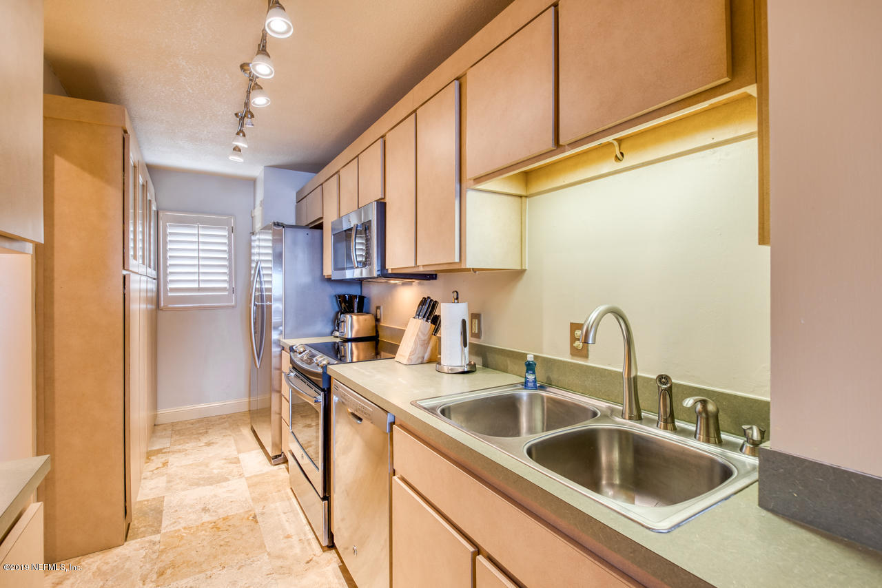 8550 A1A South, Unit 408 St. Augustine, FL 32080 - Photo 8 of 33 a kitchen with stainless steel appliances granite countertop a sink dishwasher and cabinets with wooden floor