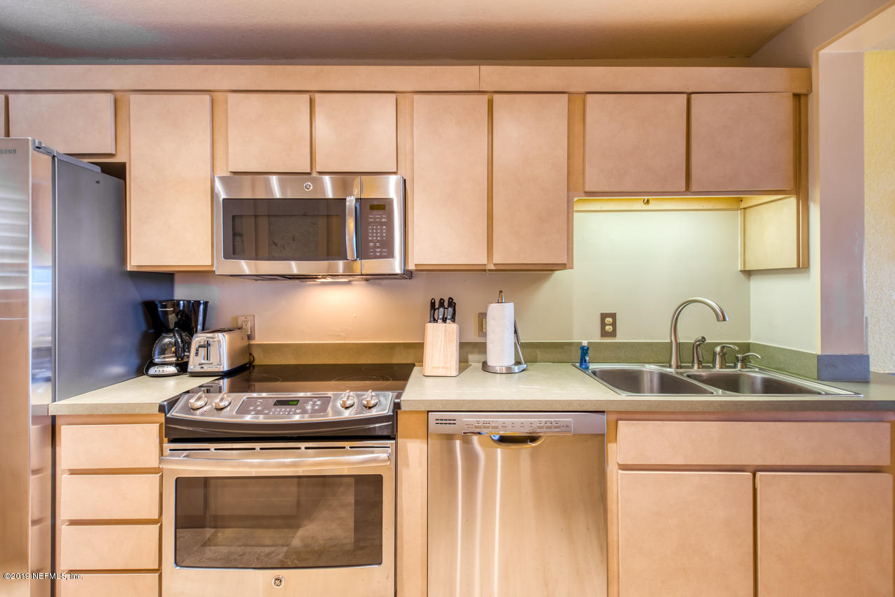 8550 A1A South, Unit 408 St. Augustine, FL 32080 - Photo 10 of 33 a kitchen with stainless steel appliances granite countertop a sink stove and microwave