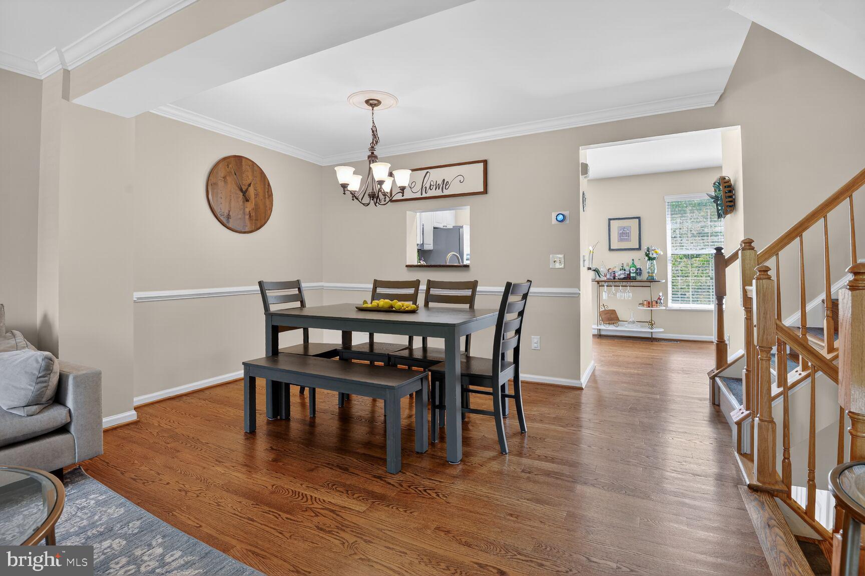 917 Rolfe Place Alexandria, VA 22314 - Photo 7 of 34 a view of a dining room and livingroom with furniture wooden floor a rug a fireplace and a chandelier