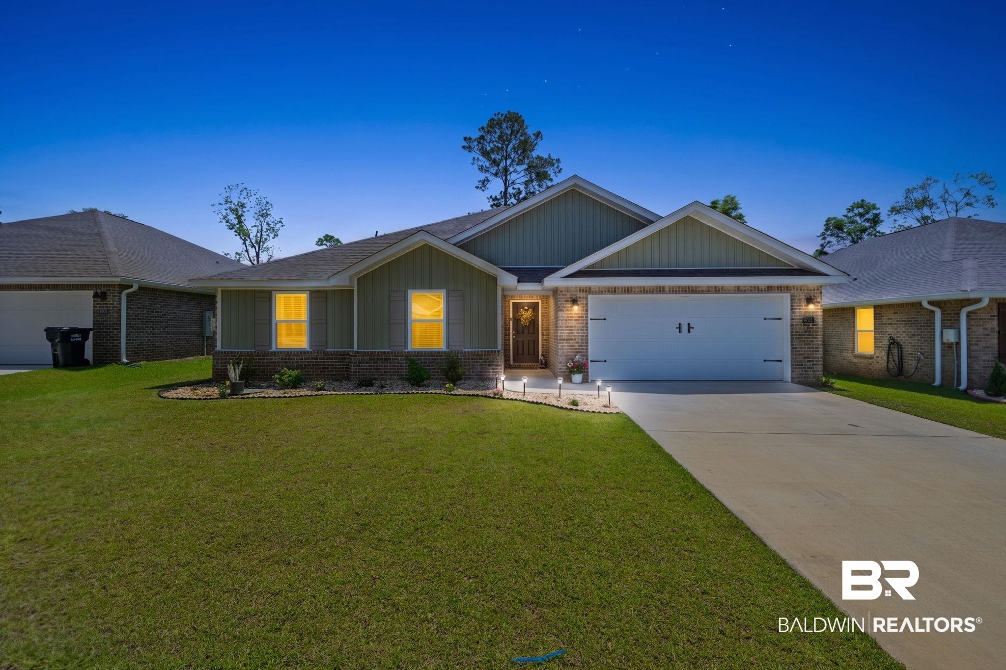 8021 Valor Rdg Way North Mobile, AL 36619 - Photo 2 of 34 Single-story residence featuring a two-car garage with overhead lighting, a brick and siding facade, and a concrete driveway