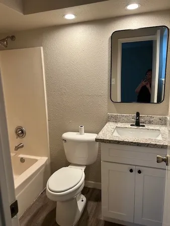 a view of a room with kitchen island stainless steel appliances wooden floor and living room view