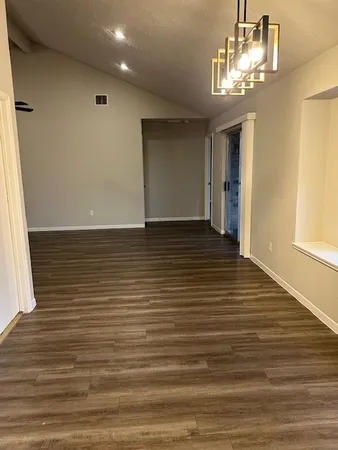 a kitchen with granite countertop wooden floors and white stainless steel appliances