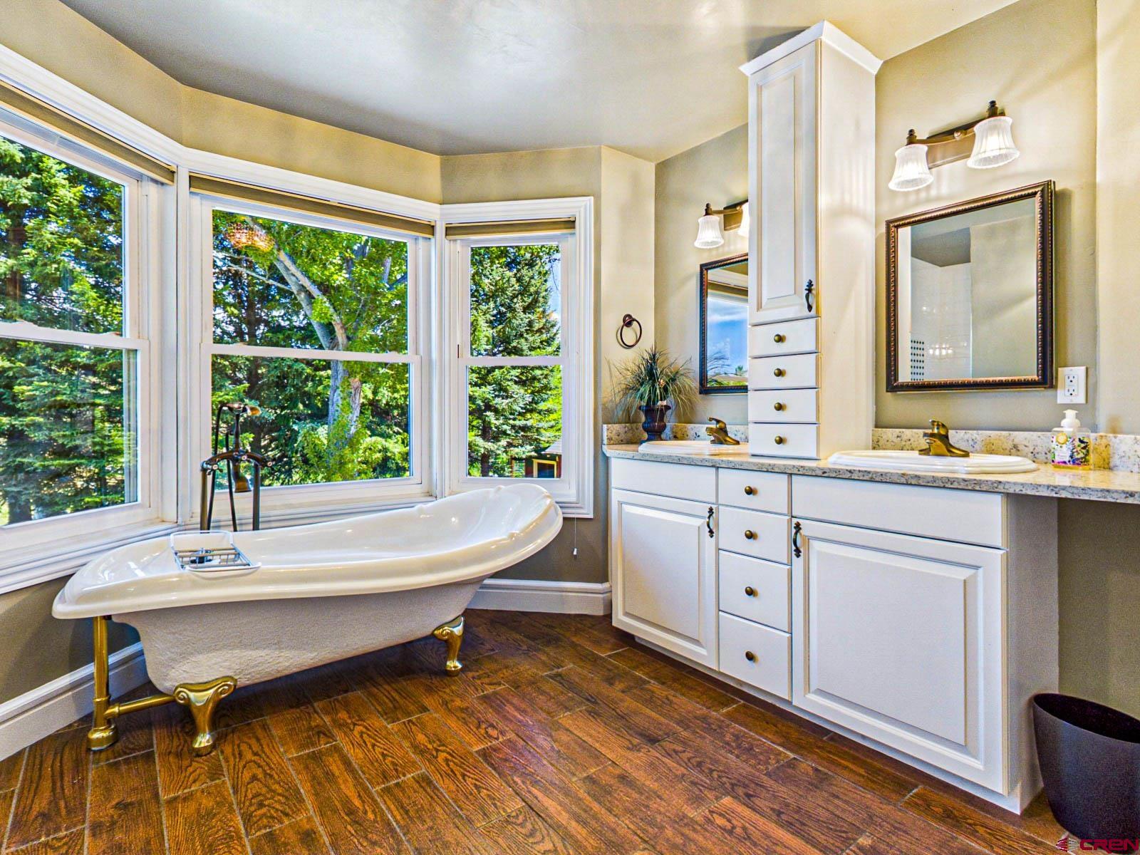 16331 2550th Road Cedaredge, CO 81413 - Photo 29 of 45 a spacious bathroom with a double vanity sink a mirror and a bathtub