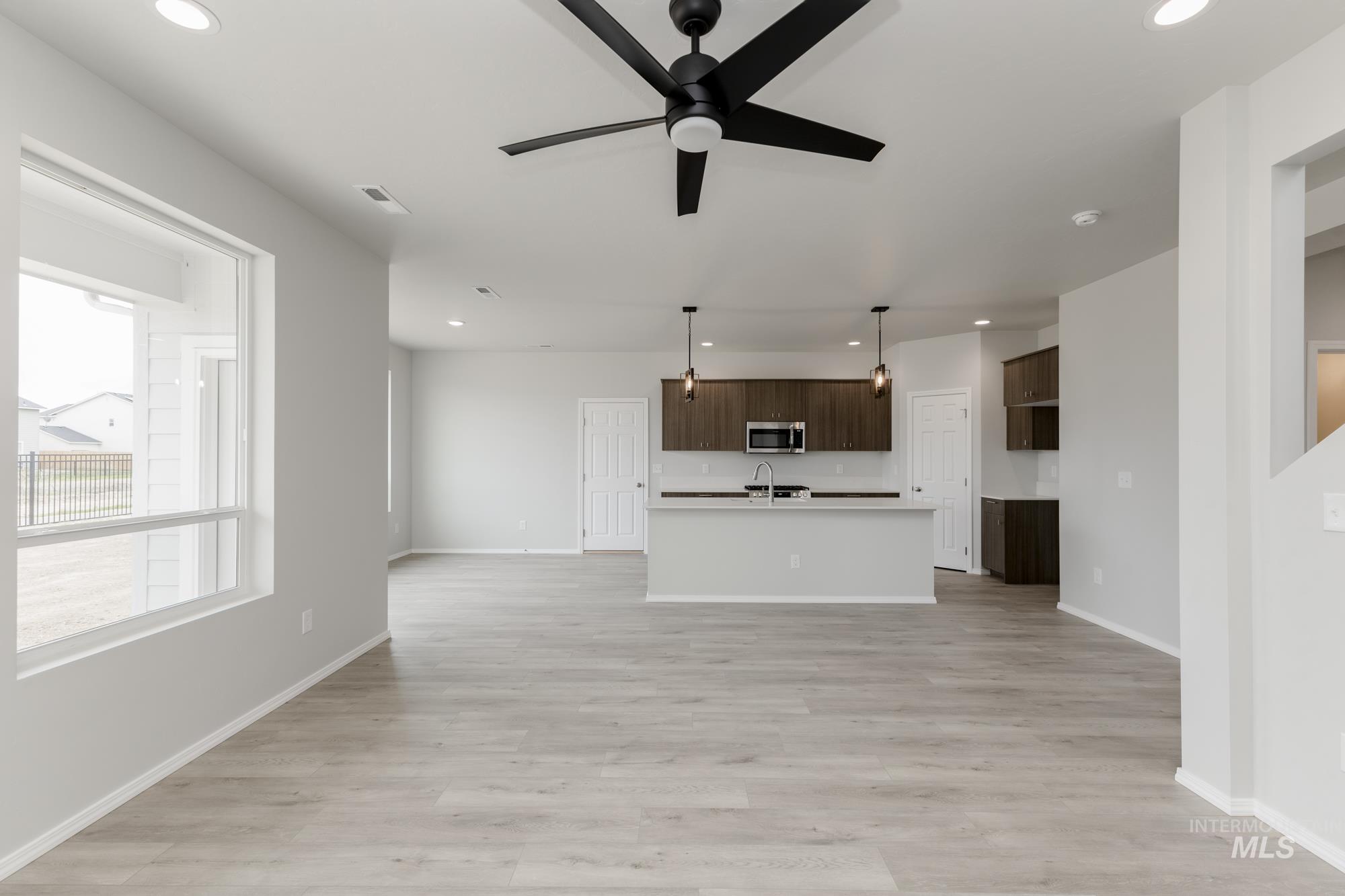 12842 Ropers Street Nampa, ID 83651 - Photo 12 of 29 Open-concept living area featuring light wood-finish flooring, a contemporary ceiling fan, and recessed lighting