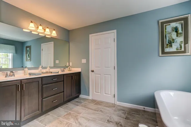a spacious bathroom with a double vanity sink and a mirror