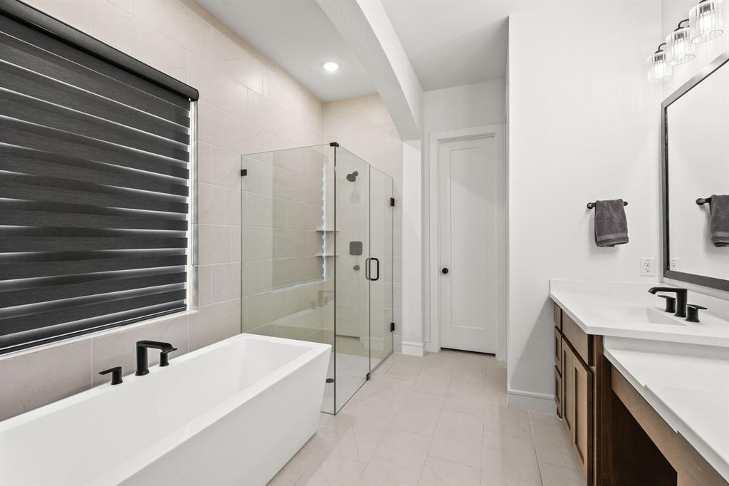 4805 Impression Lane Prosper, TX 75078 - Photo 16 of 34 a bathroom with a tub sink and mirror
