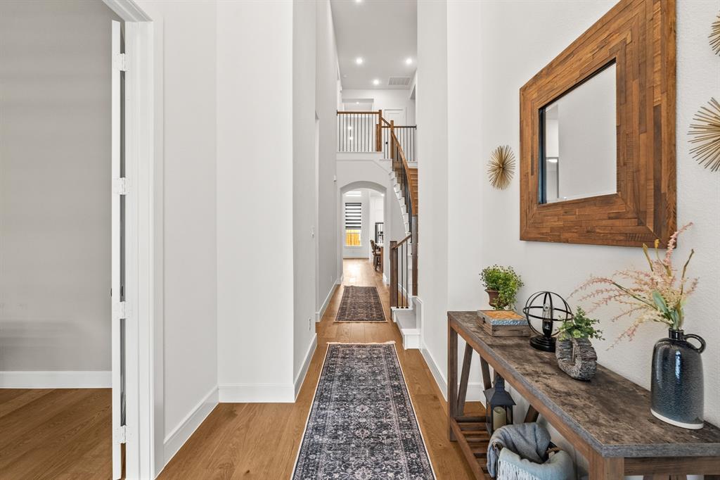 4805 Impression Lane Prosper, TX 75078 - Photo 2 of 34 a view of a hallway with furniture and wooden floor