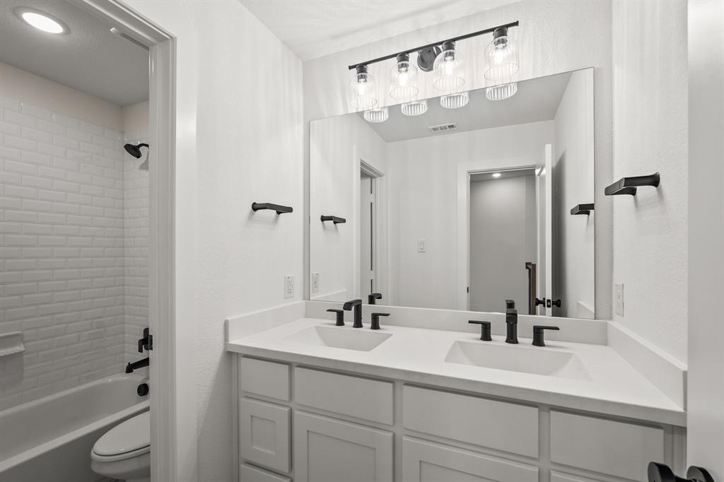 4805 Impression Lane Prosper, TX 75078 - Photo 22 of 34 a bathroom with a sink vanity granite toilet tub and shower