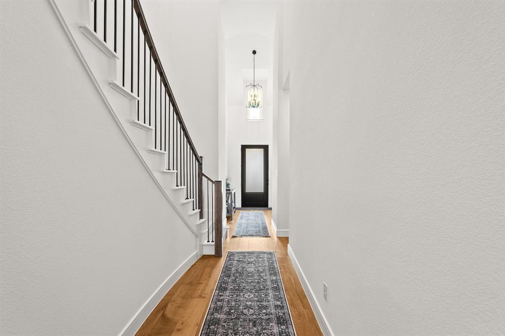 4805 Impression Lane Prosper, TX 75078 - Photo 7 of 34 a view of a hallway with wooden floor and entryway