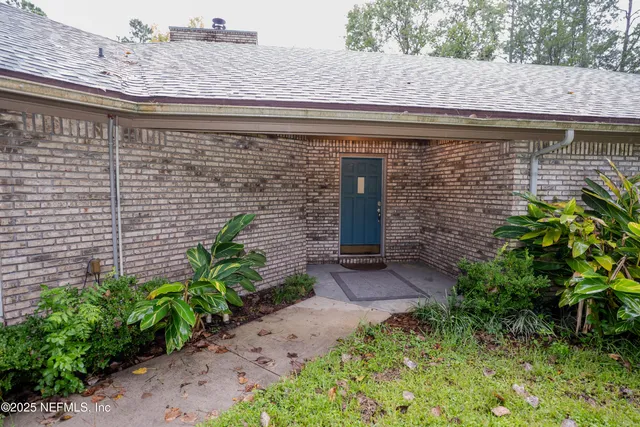 a front view of a house with plants