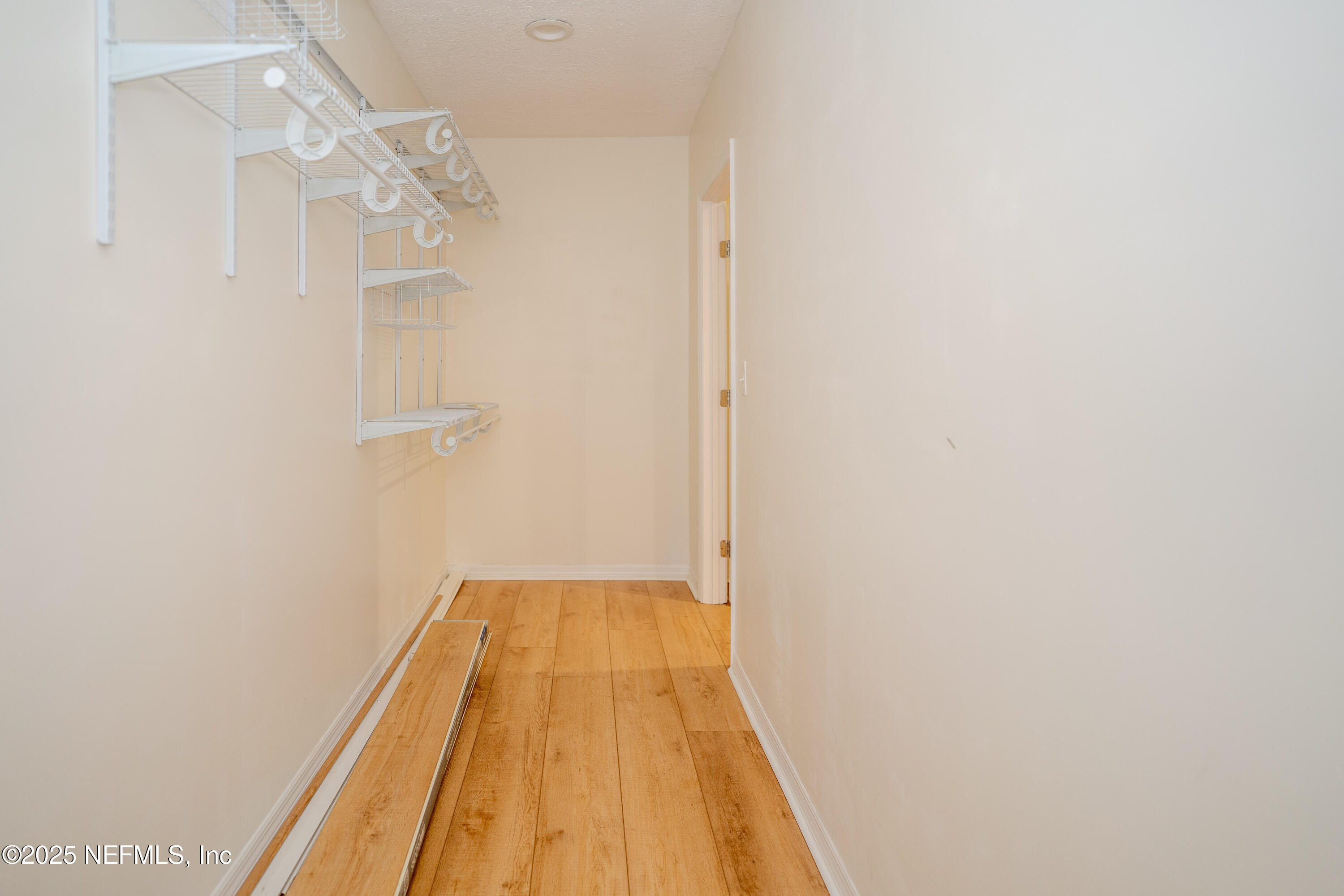 3098 Pacetti Road, Unit I St. Augustine, FL 32092 - Photo 21 of 29 a view of a hallway with wooden floor and a chandelier