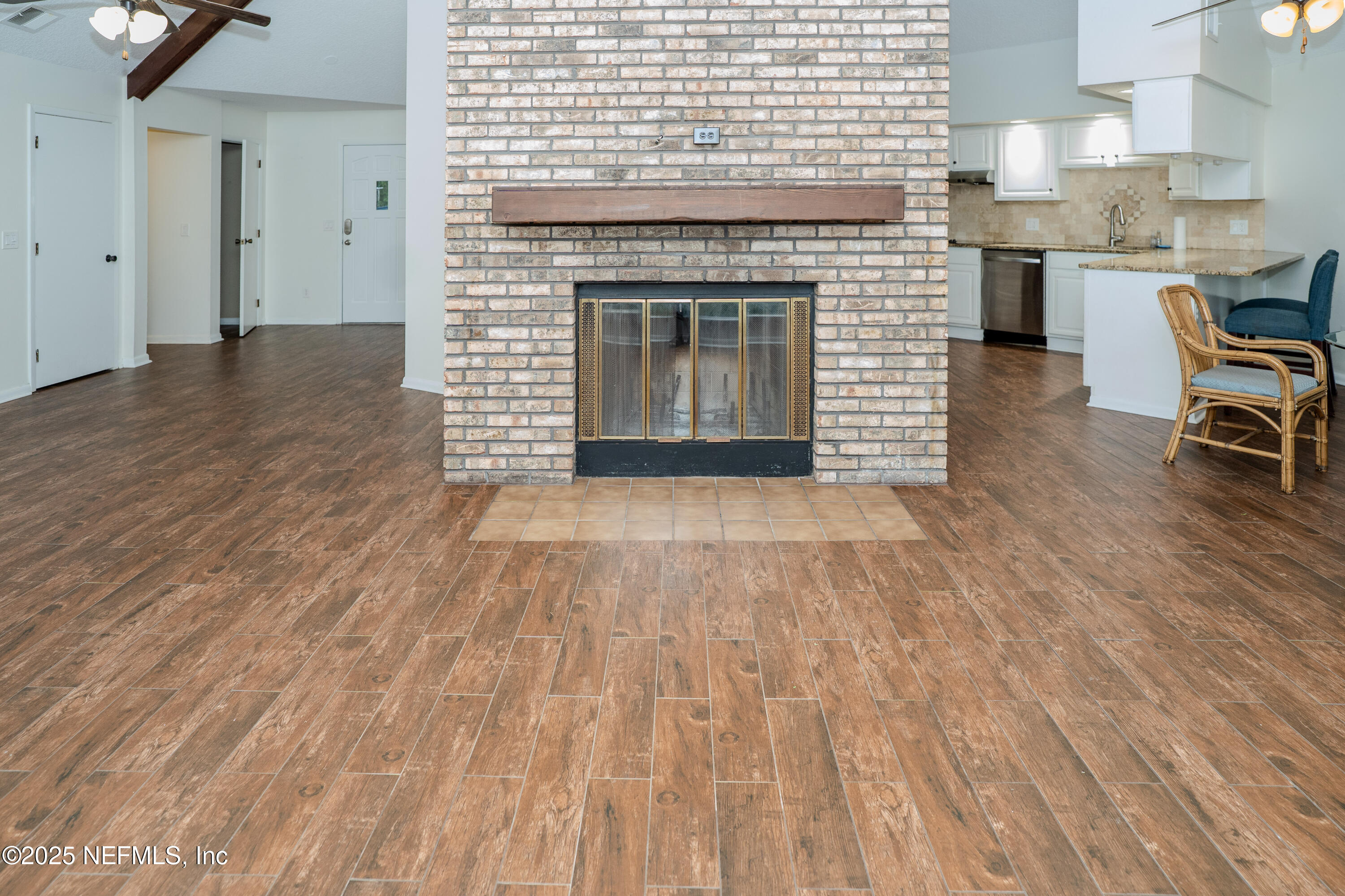3098 Pacetti Road, Unit I St. Augustine, FL 32092 - Photo 5 of 29 an empty room with wooden floor and fireplace