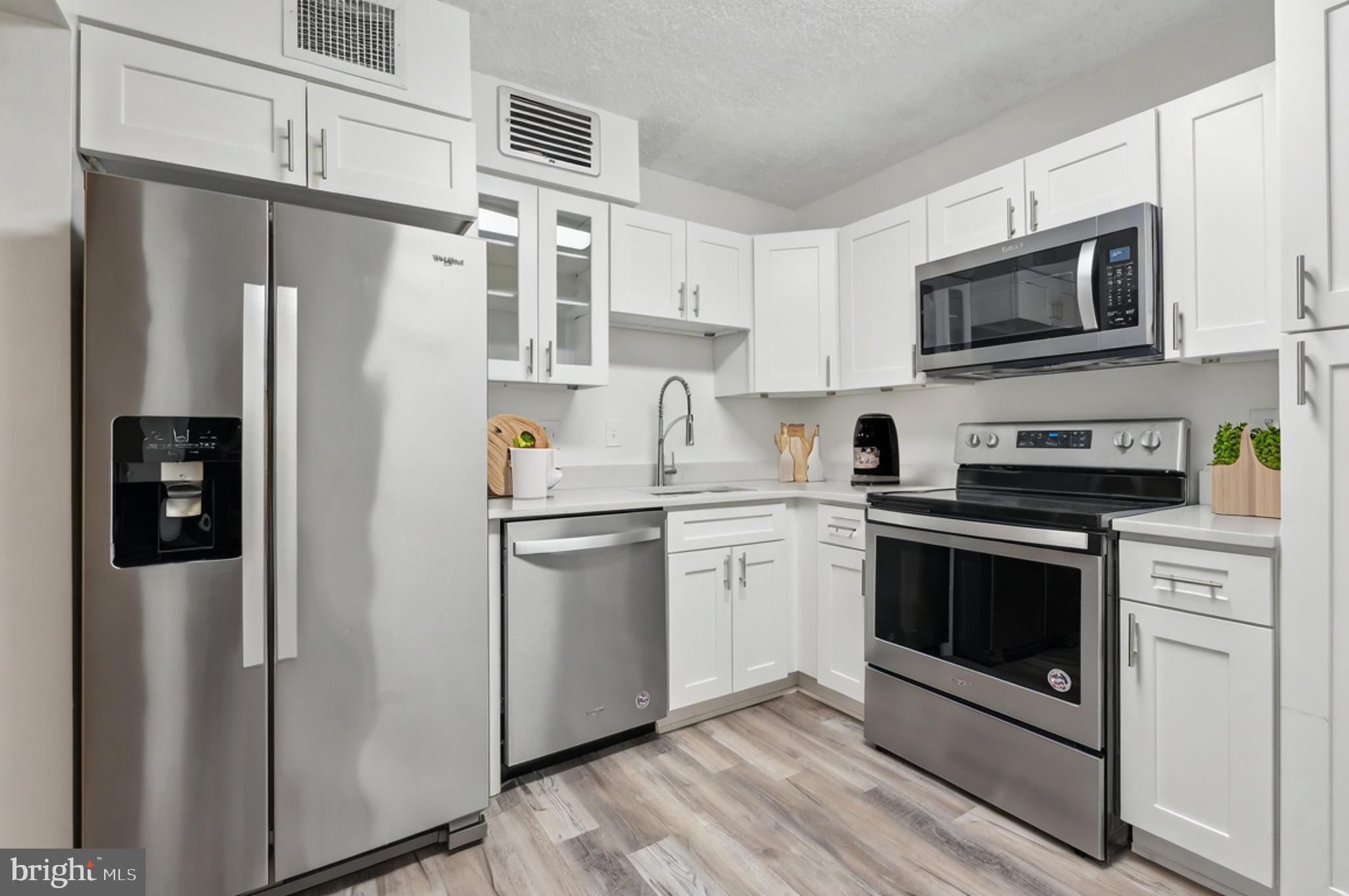 1800 Old Meadow Road, Unit 115 McLean, VA 22102 - Photo 16 of 35 a kitchen with stainless steel appliances a refrigerator stove and microwave