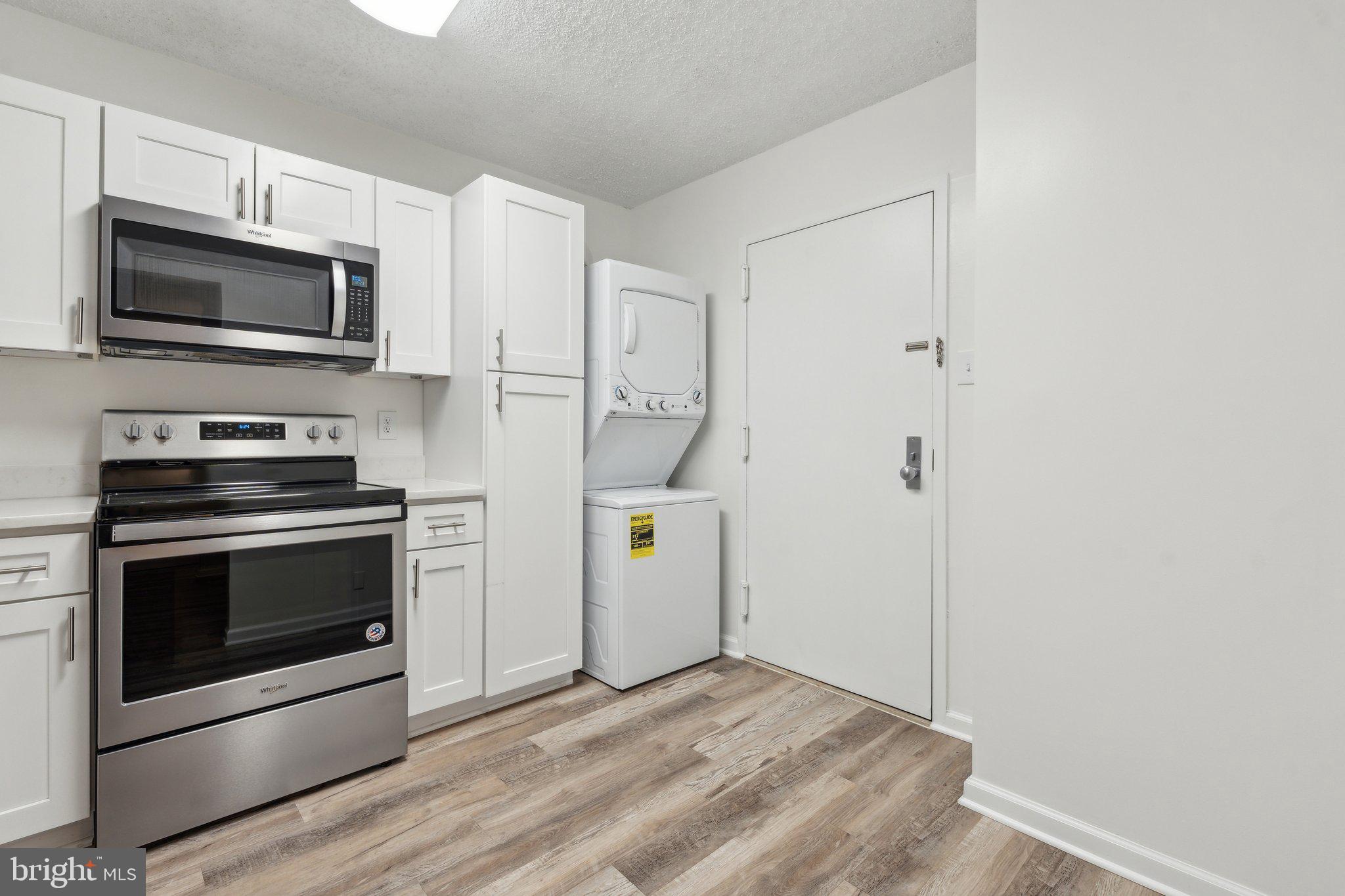 1800 Old Meadow Road, Unit 115 McLean, VA 22102 - Photo 17 of 35 a kitchen with white cabinets and stainless steel appliances